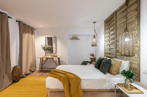 1 dormitorio con cama blanca y pared de madera en BNBHolder The Elegance Chueca, en Madrid