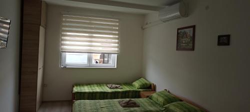 a bedroom with a bed and a window with blinds at Apartman Bane in Soko Banja