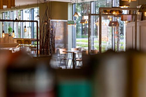a restaurant with tables and chairs and windows at Hotel MODI in Dachau