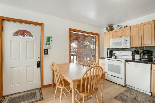 a kitchen with a wooden table and chairs and a door at Samuel's Haven in Rockaway Beach