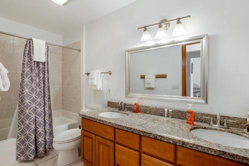 a bathroom with a sink and a toilet and a mirror at Samuel's Haven in Rockaway Beach