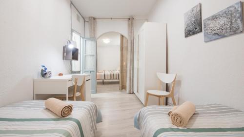 1 dormitorio con 2 camas, escritorio y 1 habitación en Toledo Feliz Apartments, en Toledo