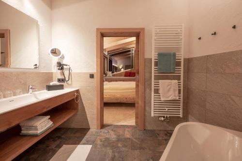 a bathroom with a tub and a sink and a toilet at Das Elisabeth in Sankt Anton am Arlberg