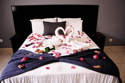 two flamingos laying on a bed with a blanket at Hotel Al-Khalil Matola in Matola