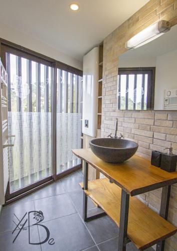 La salle de bains est pourvue d'un lavabo sur une table en bois. dans l'établissement residence de porticcio, youyoube, à Porticcio