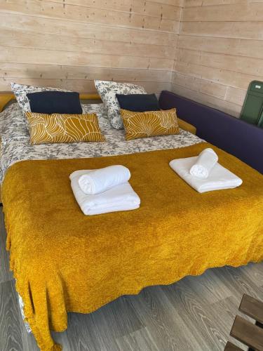 een groot bed met twee witte handdoeken erop bij T1bis dans les dunes du Cap Ferret in Cap-Ferret