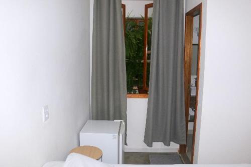 a living room with a window and a mirror at Hotel Laundos in Sao Paulo