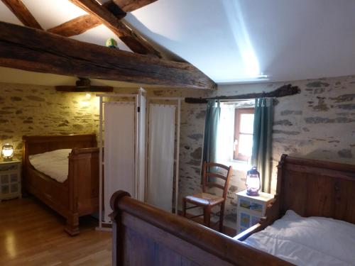 une chambre avec un lit et une chaise dans une pièce dans l'établissement Domaine de la Garneraie, à Le Champ-Saint-Père