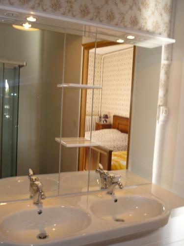 une salle de bain avec un lavabo et un miroir dans l'établissement Domaine de la Garneraie, à Le Champ-Saint-Père