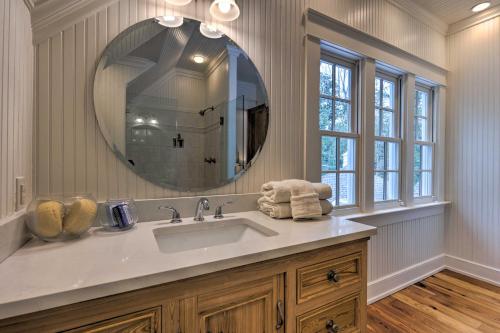 a bathroom with a sink and a large mirror at Luxe Fairhope Home with Covered Patio Walk to Bay in Fairhope