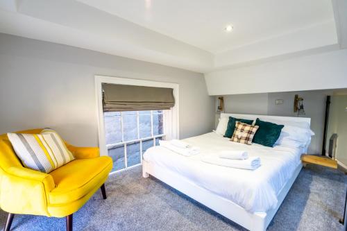 1 dormitorio con 1 cama y 1 silla amarilla en The School House, en York