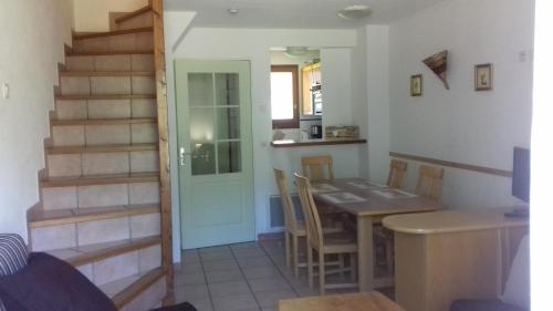 une cuisine et une salle à manger avec une table et un escalier dans l'établissement Appartement 24 Les Chalets du Jardin Alpin, à La Salle Les Alpes
