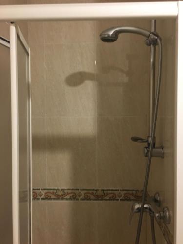 a shower with a glass door in a bathroom at Hostal O Patron in Santiago de Compostela