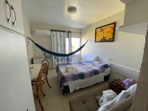 ein Schlafzimmer mit einem Bett und einem Sofa in einem Zimmer in der Unterkunft Carneiros Tamandare Apart Hotel Marinas in Tamandaré