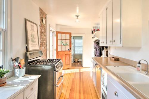 a kitchen with white cabinets and a stove top oven at Charming Sharon Dwelling with Deck and Fire Pit! in Sharon