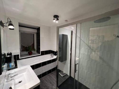 ein Bad mit einer Badewanne, einem Waschbecken und einer Dusche in der Unterkunft Appartement privé in Lourdes