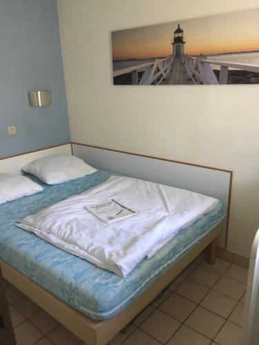 - un lit dans une chambre avec une photo sur le mur dans l'établissement APPARTEMENT PORT BOURGENAY proche MER VENDEE 85, à Talmont-Saint-Hilaire