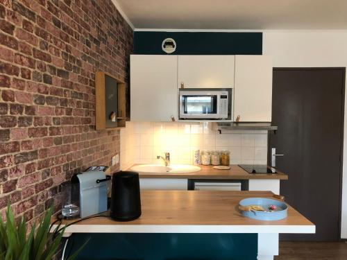 une cuisine avec un comptoir avec un évier et un micro-ondes dans l'établissement Studio avec balcon & parking gratuit - Tours Gare, à Tours