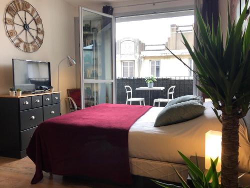 a bedroom with a bed and a tv and a table at Studio avec balcon & parking gratuit - Tours Gare in Tours