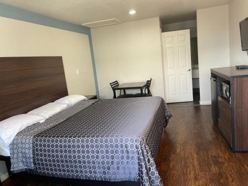 a bedroom with a bed and a dresser and a door at Garden Inn Motel in San Antonio