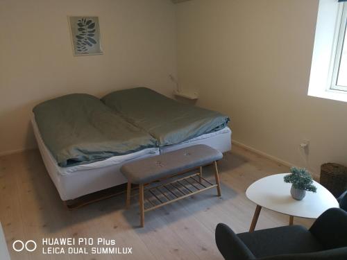 a small bedroom with a bed and a table at Landevejens B&B Holstebro in Holstebro