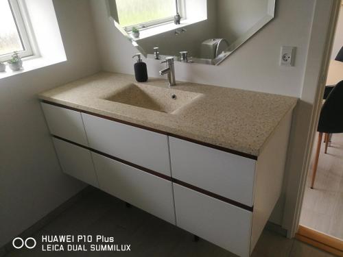 a bathroom with a sink and a mirror at Landevejens B&B Holstebro in Holstebro