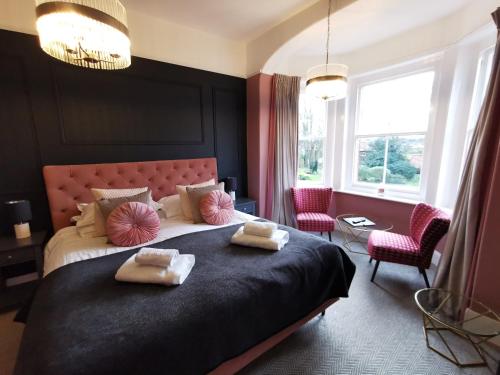 a bedroom with a large bed with two pillows on it at Blakeney House in Blakeney