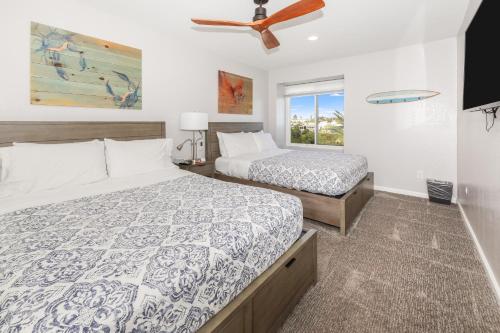 a bedroom with two beds and a ceiling fan at B306 - Endless Summer in Oceanside