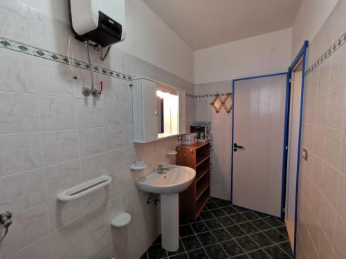 y baño blanco con lavabo y ducha. en Appartamento Ghirigoro 2, en Torre San Giovanni