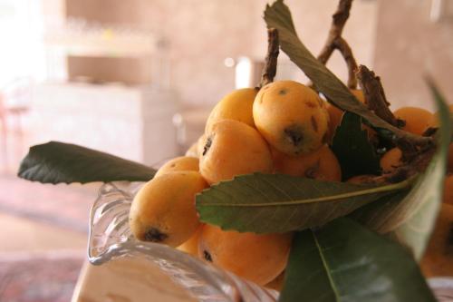 a bunch of oranges with leaves in a glass bowl at Hotel Garni Villa del Sole in Ponte Tresa