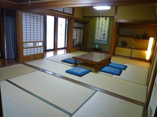 a room with a table and blue mats in a room at GuestHouse AZMO - Vacation STAY 22715v in Matsue