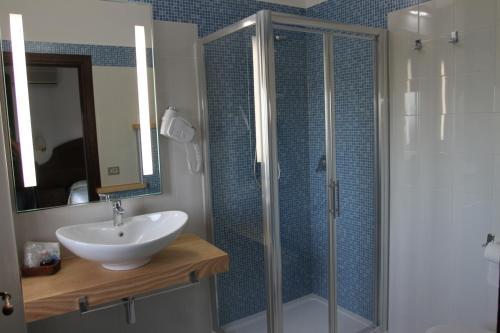 a bathroom with a sink and a glass shower at Hotel Mediterraneo in Santa Maria Navarrese