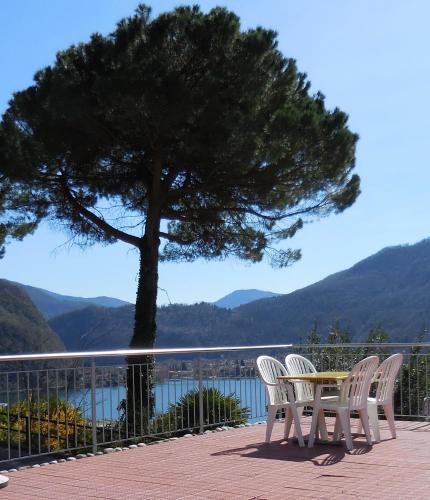 a table and chairs sitting on a patio with a tree at Hotel Garni Villa del Sole in Ponte Tresa