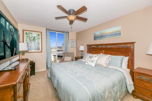 - une chambre avec un lit, un bureau et un ventilateur de plafond dans l'établissement E201 - Tropical Shores, à Oceanside