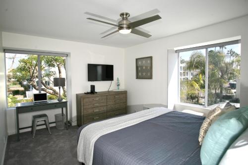 a bedroom with a bed and a desk and a tv at A300 - Pier View Paradise in Oceanside