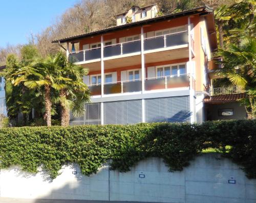 a building with a hedge in front of it at Hotel Garni Villa del Sole in Ponte Tresa