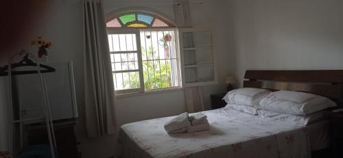 1 dormitorio con 1 cama con 2 toallas en Aconchego de um Lar Hospedagem Domiciliar, en Cabo Frío