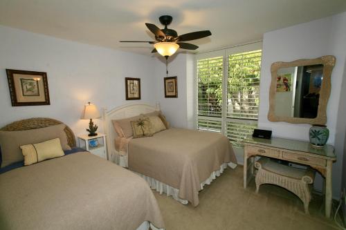 een slaapkamer met twee bedden en een plafondventilator bij D2 - Breakwater Bungalow in Oceanside