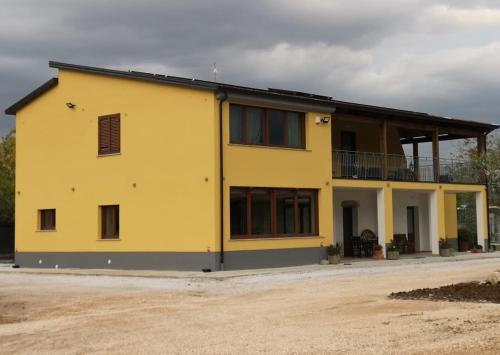 uma casa amarela com muitas janelas em Agriturismo B&B Dal Professore em Sicignano degli Alburni