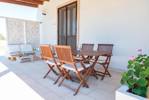 a wooden table and chairs on a patio at Agriturismo Villa Tommaso in Torre dell'Orso