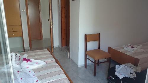 a small room with a bed and a chair at Veroniki Hotel in Kos Town