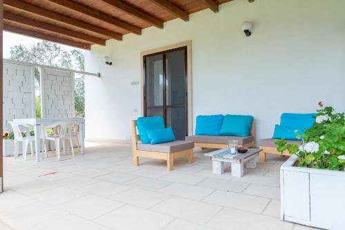 a patio with blue chairs and a table at Agriturismo Villa Tommaso in Torre dell'Orso