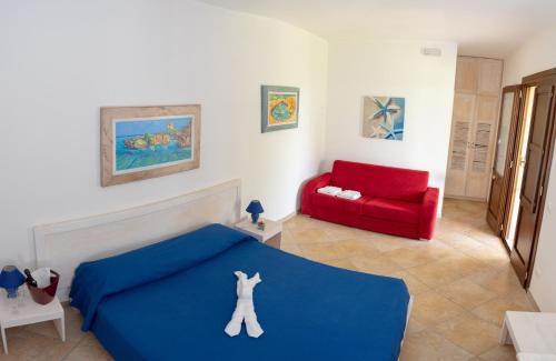 1 dormitorio con 1 cama azul y 1 sofá rojo en Agriturismo Villa Tommaso en Torre dell'Orso
