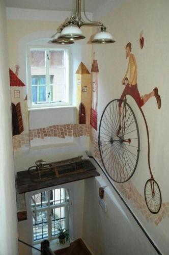 a painting of a man riding a bike on a wall at Penzion Nostalgia in Banská Štiavnica