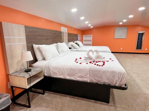 a bedroom with a large bed with an orange wall at Hollywood Motel in Farmingdale