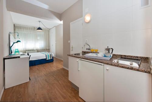 uma cozinha com um lavatório e uma cama num quarto em Estudios Aránzazu em Santander