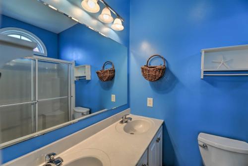 Baño azul con lavabo y aseo en Waterfront Emerald Isle Home with Dock Access! en Emerald Isle