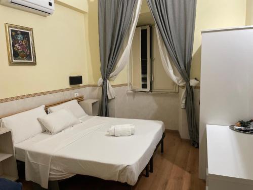 a bedroom with a white bed and a window at Conte House merulana guesthouse in Rome