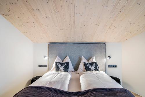 a bedroom with a large bed with a wooden ceiling at Erika Suites & Lofts in Stanghe