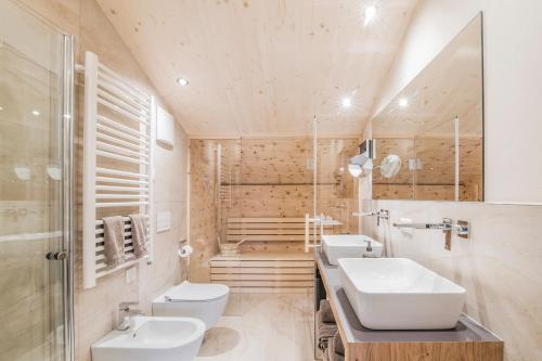 a bathroom with two sinks and two toilets at Erika Suites & Lofts in Stanghe
